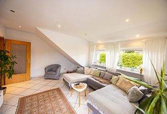 Wohnzimmer mit Gaube über fast die gesamte Zimmerbreite