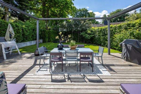 Sonnige Terrasse mit Pergola und Gartenblick