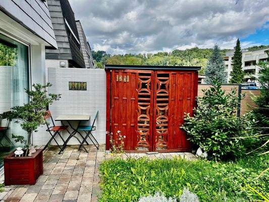 Ein Holzlager im kleinen Garten vor dem Haus