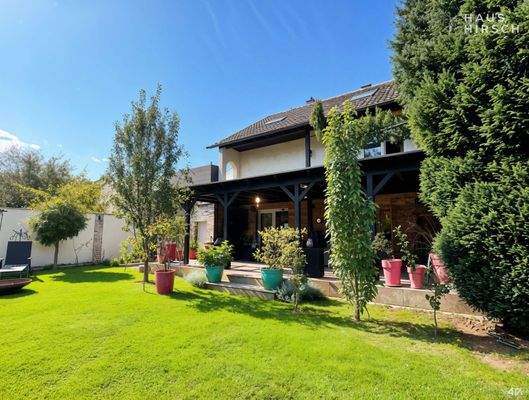 Haus und Garten mit Obstbäumen - (KI generiert)