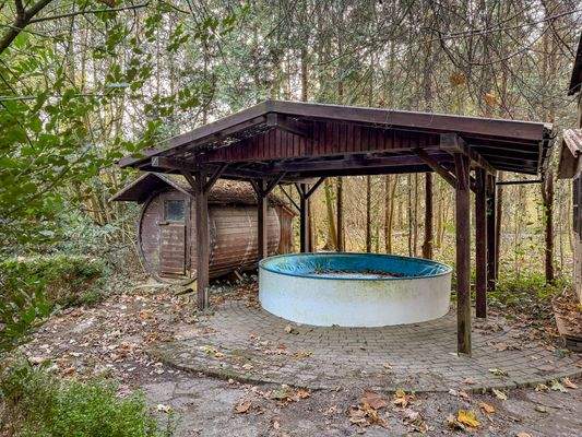 Faßsauna mit kleinem Pool im hinteren Bereich des Gartens