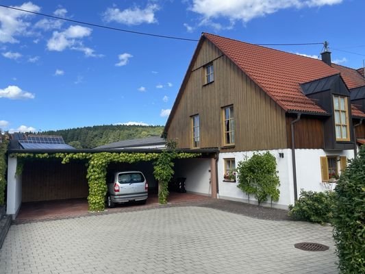 Ansicht mit Carport und vier Pkw-Außenstellplätzen