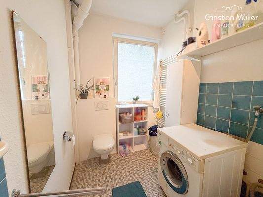 Tageslicht-Badezimmer mit Duschbadewanne und Waschmaschinenanschluss