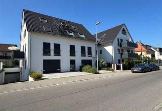 Das Gebäudeensemble mit Tiefgaragenzufahrt (li.)