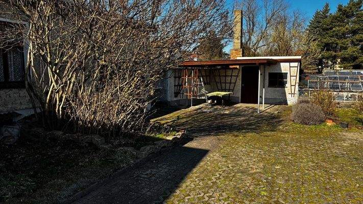 massives Nebengebäude mit überdachtem Freisitz