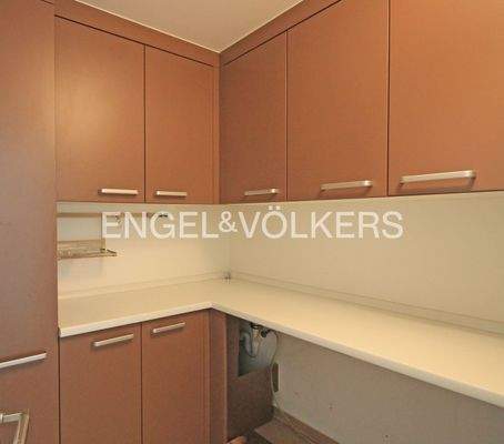 Hauswirtschaftsraum mit Einbauschränken und Platz für Waschmaschine und Trockner