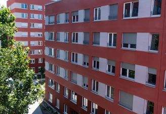 Blick auf die Vorderansicht der Mehrfamilienhäuser mit roter Fassade