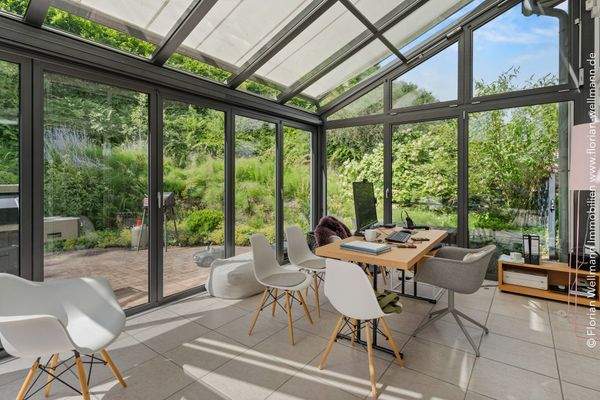 Harmonisch in die Umgebung integrierter Wintergarten mit Terrassenzugang, Fußbodenheizung und Beschattung