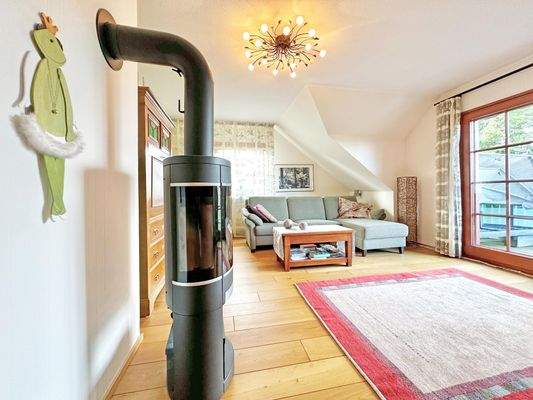 Wohnbereich im DG mit Kamin und Zugang zum Balkon