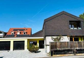 Südansicht mit ansprechender Schieferoptikfassade und Doppelgarage