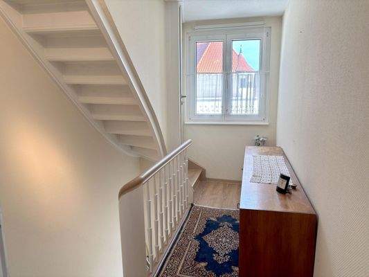 heller Flur mit Holztreppen