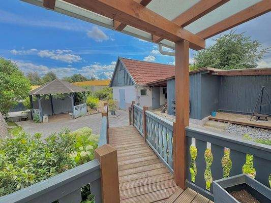 Überdachte Terrasse mit Zugang zum Garten und zu den Nebengebäuden