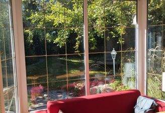 Blick aus dem Wohnzimmer in den Garten mit großem Apfelbaum