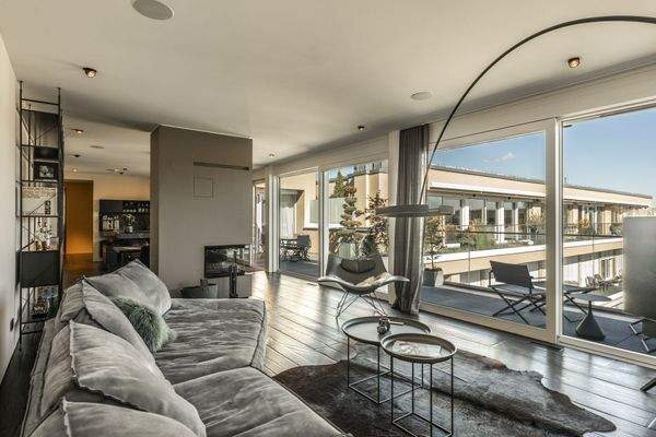 Wohnlounge mit Kamin und durchgehender Fensterfron