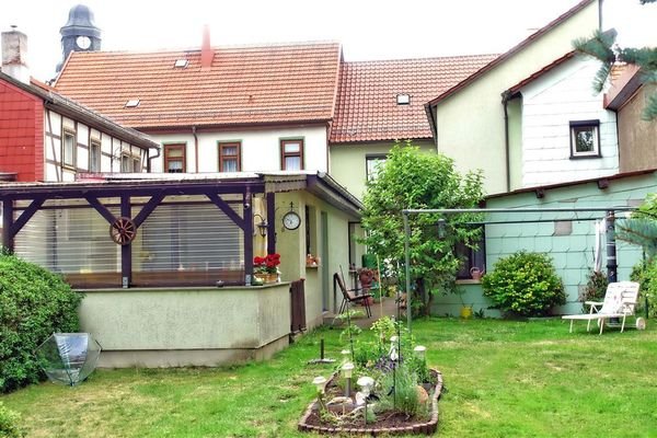 Garten mit überdachter, gepflasteter Sitzecke