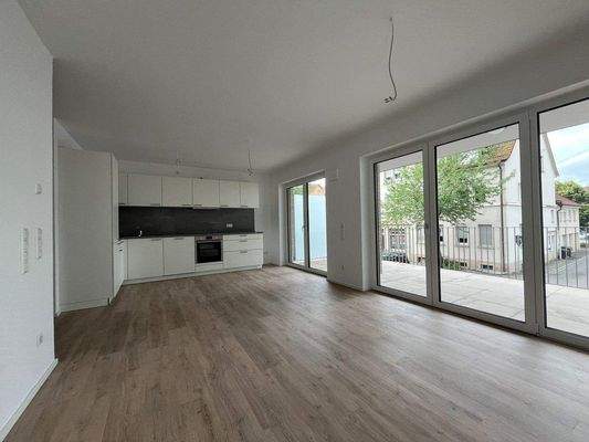 Wohnbereich mit offener Kücheund Balkon.JPEG