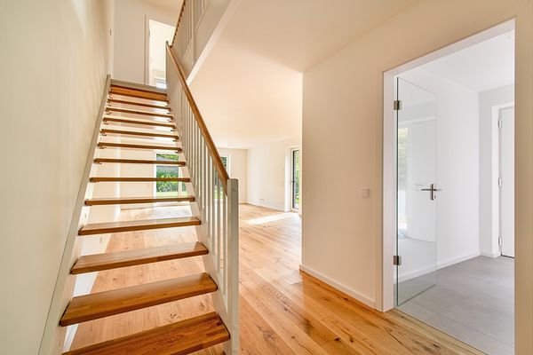 Treppe mit Blick ins offene Wohnzimmer und in den Eingangsbereich