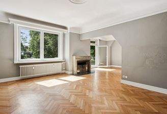 Helles und offenes Wohnzimmer mit Kamin und Zugang zum Balkon