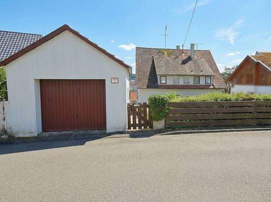 Hausansicht mit Garage und Garten