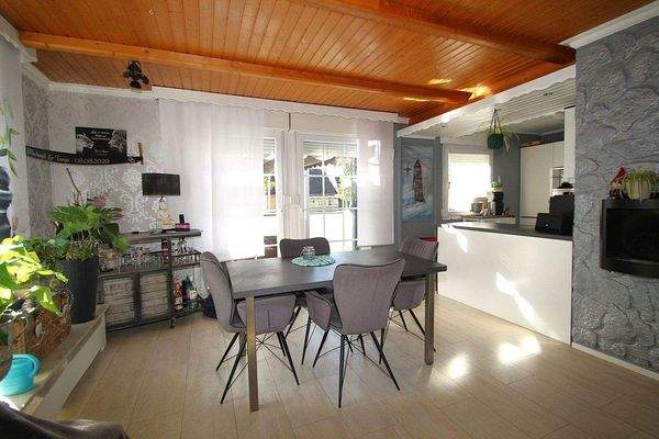 Das Wohnzimmer mit Zugang zur offenen Einbauküche