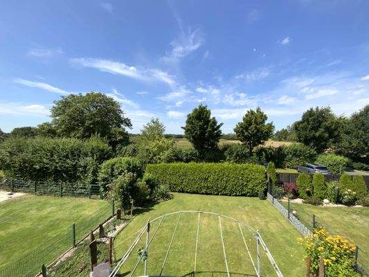 hinter dem Haus erstrecken sich weitläufige Wiesen und Felder