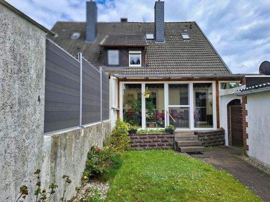 Blick zum Haus, Rückansicht und Westlage, überdachte Terrasse und ausfahrbarer Sonnenschutz