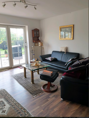 Helles Wohnzimmer mit großzügigem Schnitt, großen Fenstern und direktem Zugang zum Außenbereich – ideal für gemütliche Wohnmomente