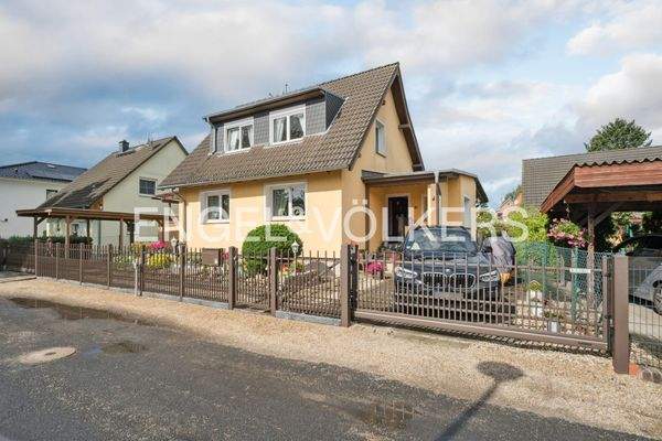 Frontansicht mit Stellplatz rechts und Carport links