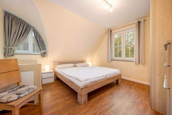 helles Schlafzimmer mit Fledermausgaube und Fenste