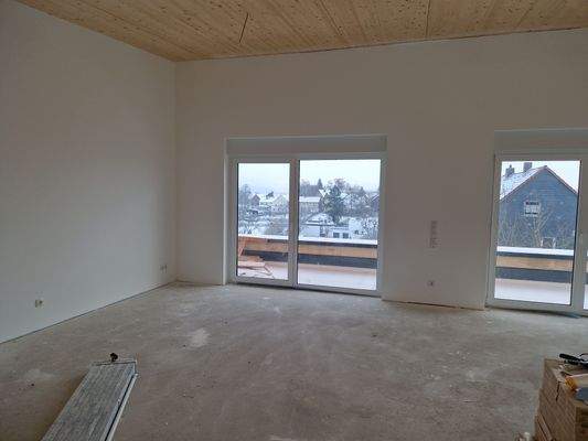 Wohnzimmer mit Blick auf Terrasse und Ort