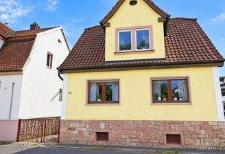 Gelbes Wohnhaus mit Giebelfenster und Nummer