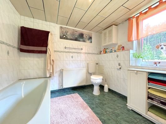 Badezimmer mit Badewanne und Waschmaschinenanschluss