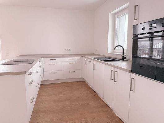 Große, moderne Einbauküche mit durchdachtem Raumkonzept