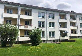 Karpatenstraße 12 Rückansicht eines Mehrfamilienhauses mit Balkonen in grüner Umgebung 