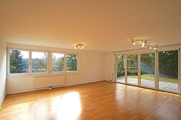 Wohnzimmer mit Fensterreihe nach Süden und Ausgang auf die Terrasse und in den Garten