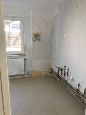 Küche mit tapetenfreien Wänden und hellem Linoleumboden