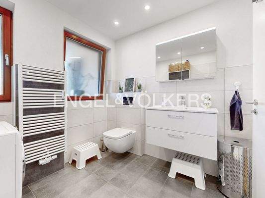 Modernes Bad mit bodengleicher Dusche, Fenster und Waschmaschinenanschluss