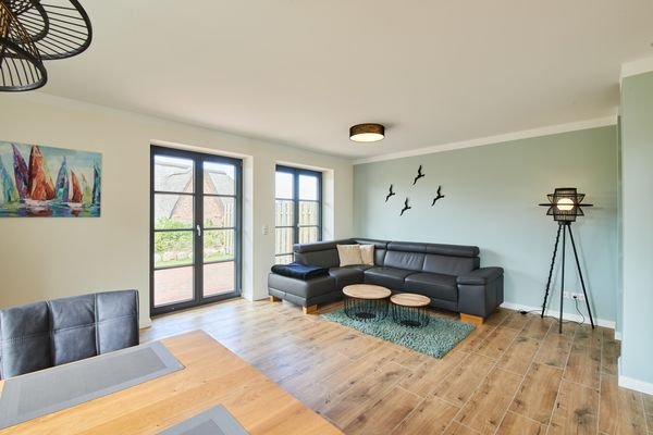 Das Wohnzimmer mit bodentiefen Sprossenfenstern