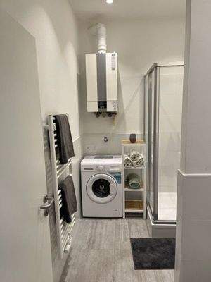 Badezimmer mit Dusche und Waschmaschine