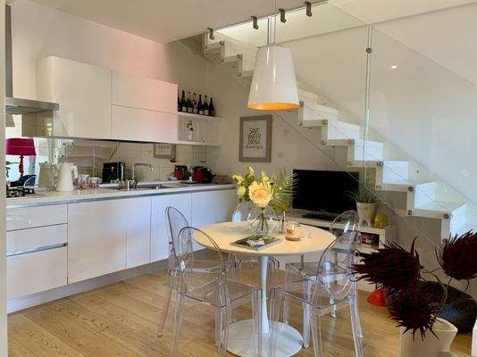 Der Essplatz mit offener Einbauküche und Treppe 