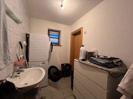 Funktionaler Hauswirtschaftsraum mit Waschmaschine und Stauraum