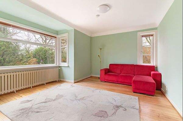 Großzügiges Wohnzimmer einer Wohneinheit mit großer Fensterfront