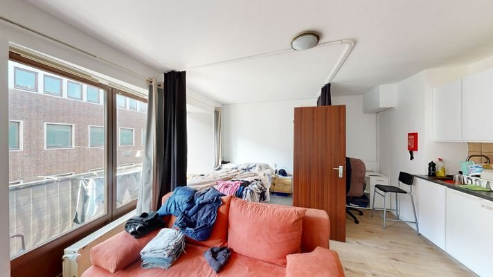 Wohn- und Esszimmer mit Schlafbereich und Küchenzeile.