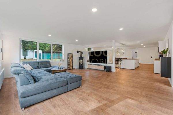 Großer Wohnzimmerabschnitt mit offenem Übergang in Küche und Essbereich