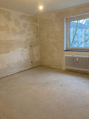 Schlafzimmer mit weißem Heizkörper und weißem Fenster.