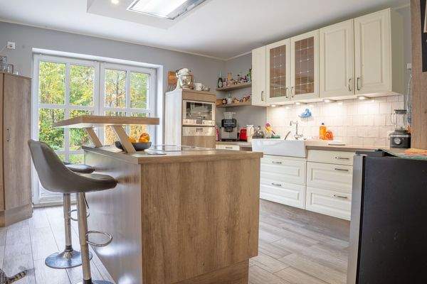 Helle Landhausküche mit Austritt zur Terrasse