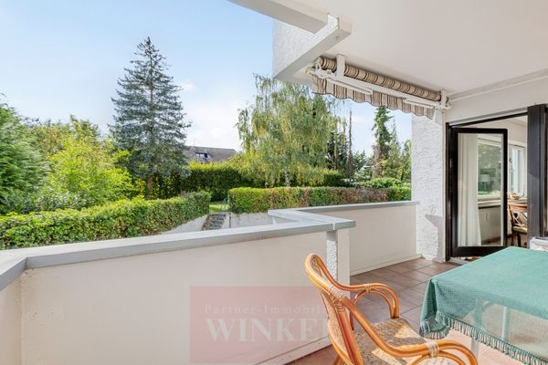 Blick vom Balkon zum Gemeinschaftsgarten über den Parkplatz hinweg