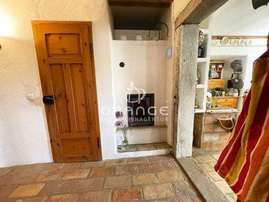 Links das Gäste WC, daneben der Kaminofen, der mit Holz befeuert werden kann