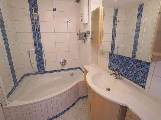 Geschmackvoll ausgestattetes Badezimmer mit Wanne, Waschbecken und WC