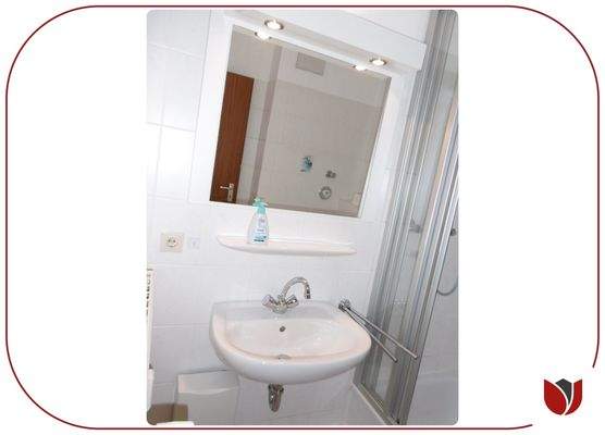 Bad mit Spiegel und Beleuchtung